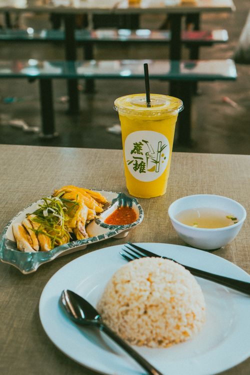 Free A delicious spread of Asian chicken rice with a refreshing drink and soup, perfect for local cuisine lovers. Stock Photo