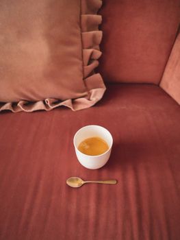 A warm espresso on a plush velvet sofa set in a cozy Vienna apartment.