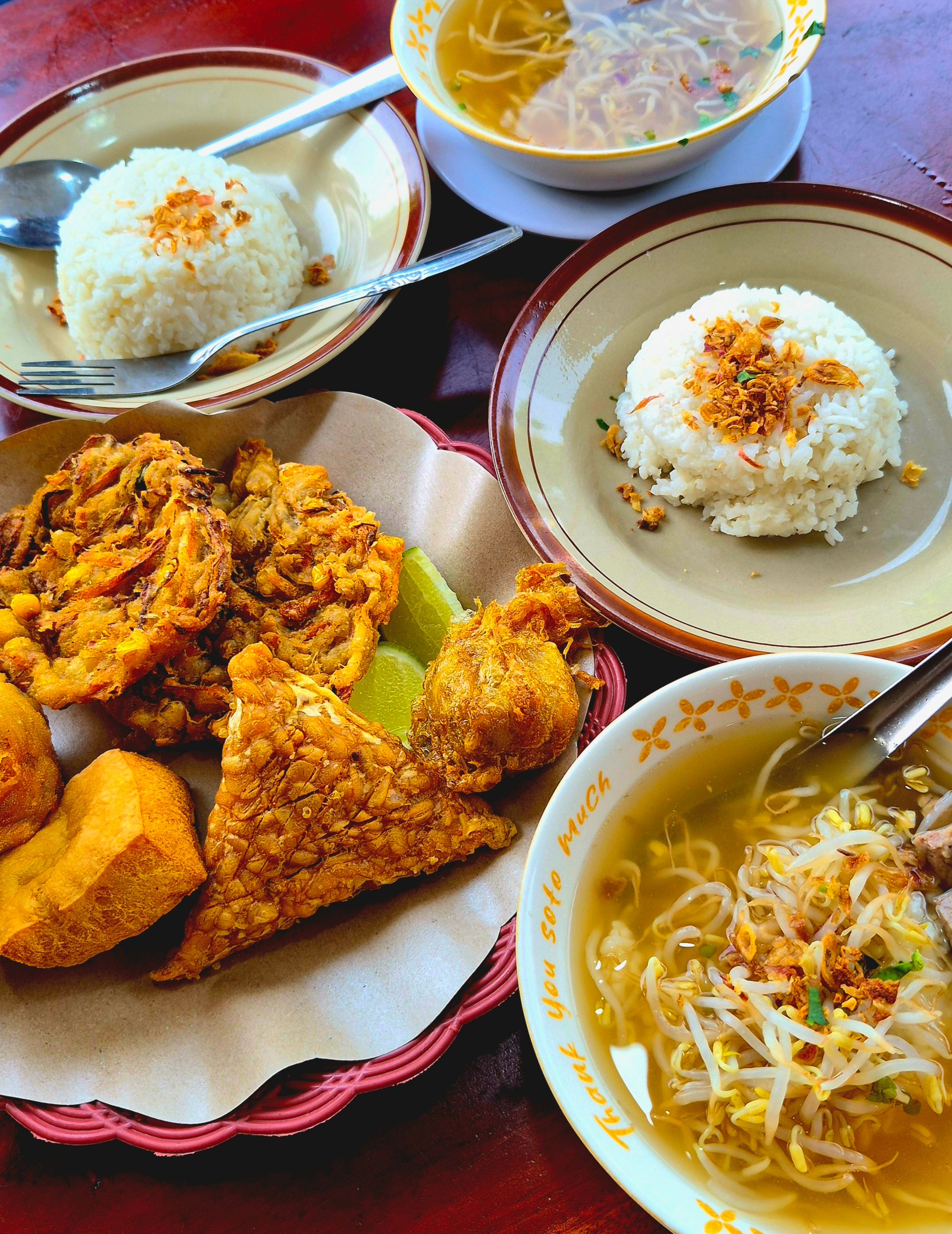 A flavorful spread of traditional Indonesian soto with rice and condiments.