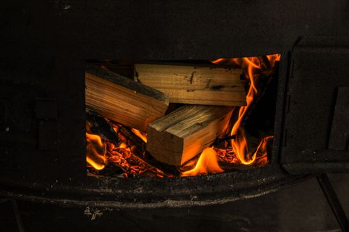 Free Close-up of firewood burning in a rustic stove, showcasing warm flames and glowing embers. Stock Photo