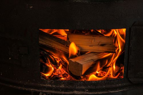 Free A warm and cozy view of firewood burning in a stove, highlighting the natural flames. Stock Photo
