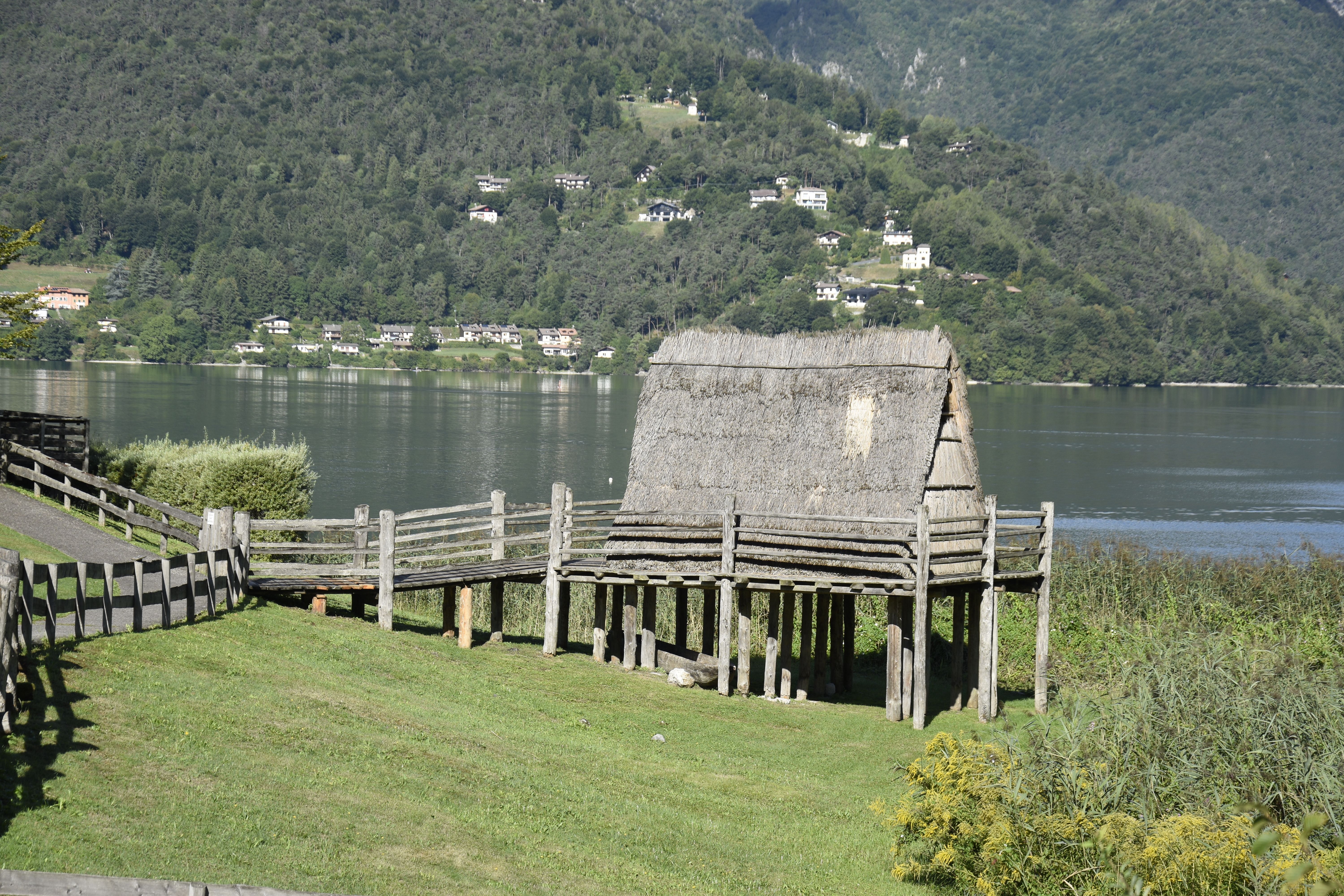 A traditional stilt house on the shores of a serene lake in Trentino-Alto Adige, Italy.