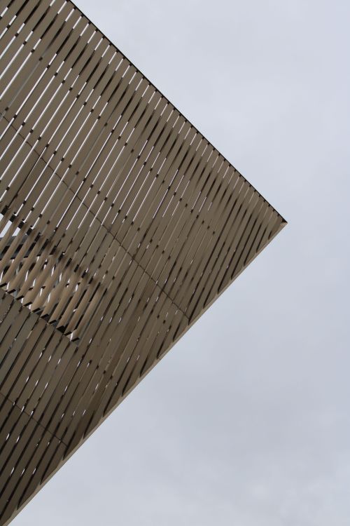 Free Abstract angle of a modern architectural structure against a cloudy sky in Mons, Belgium. Stock Photo