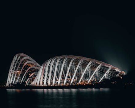 Dramatic night shot of the illuminated Flower Dome in Singapore, showcasing its modern architecture.