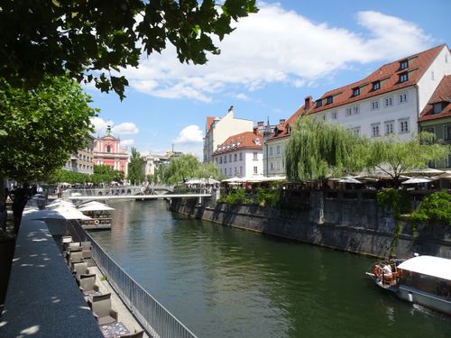 Free Picturesque view of the canal in Ljubljana, Slovenia, showcasing vibrant summer scenery. Stock Photo