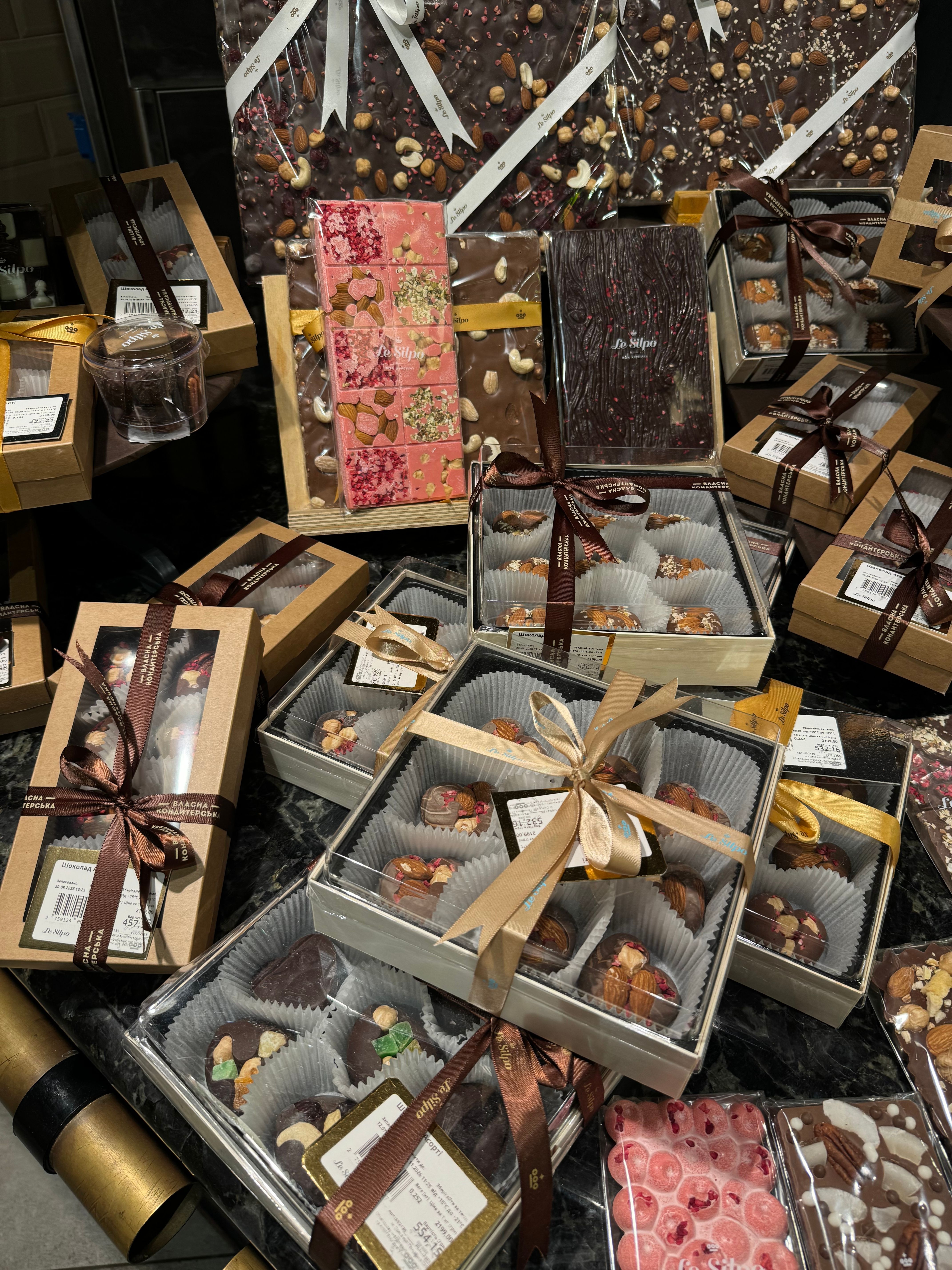 A luxurious display of gourmet chocolate gift boxes with decorative ribbons and packaging.