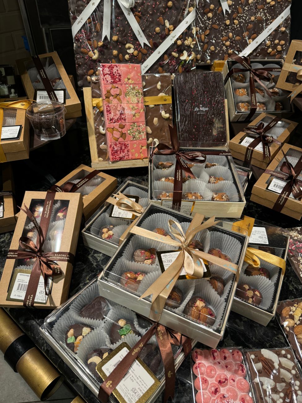 A luxurious display of gourmet chocolate gift boxes with decorative ribbons and packaging.