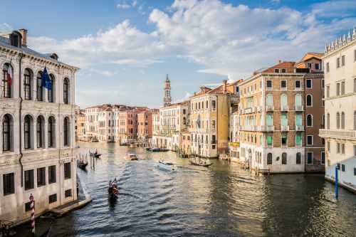 Free A picturesque view of a Venetian canal with gondolas under a clear sky. Stock Photo