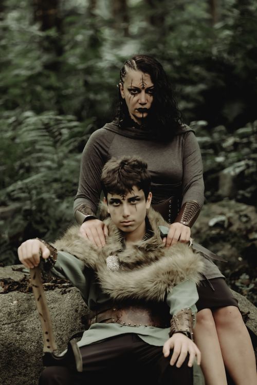 Free A medieval themed portrait with two people in a forest ambiance, featuring warriors in dramatic attire. Stock Photo