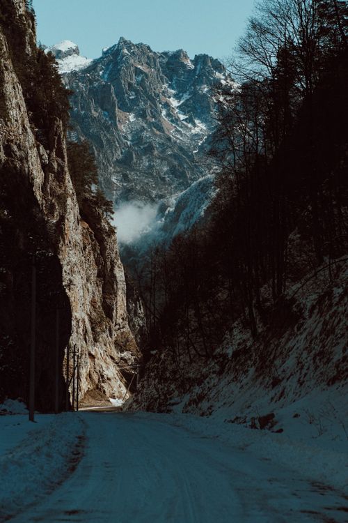 Free Serene winter landscape of a snowy road surrounded by majestic mountains in Chechnya, Russia. Stock Photo