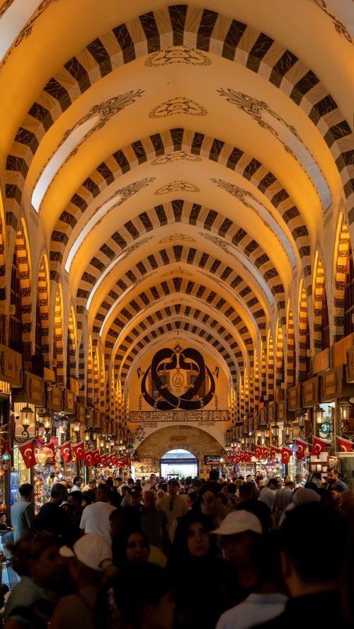 Free A crowded Turkish market showcasing intricate architectural arches and vibrant cultural atmosphere. Stock Photo