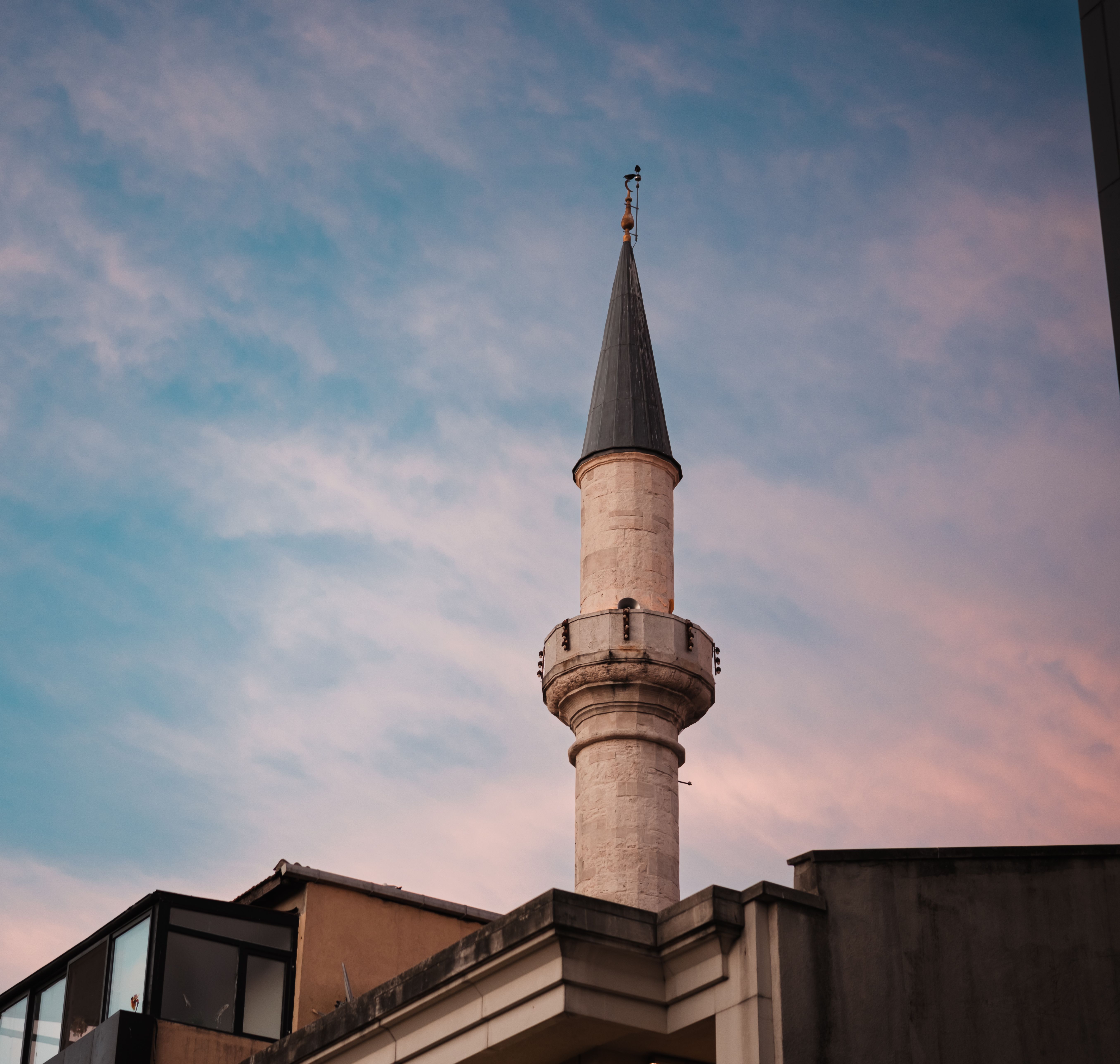 A picturesque minaret silhouetted against a colorful sunset sky, showcasing cultural architecture.