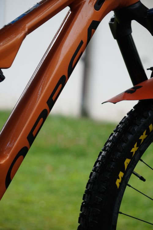 Free Detailed view of a mountain bike's orange frame and wheel outdoors. Stock Photo