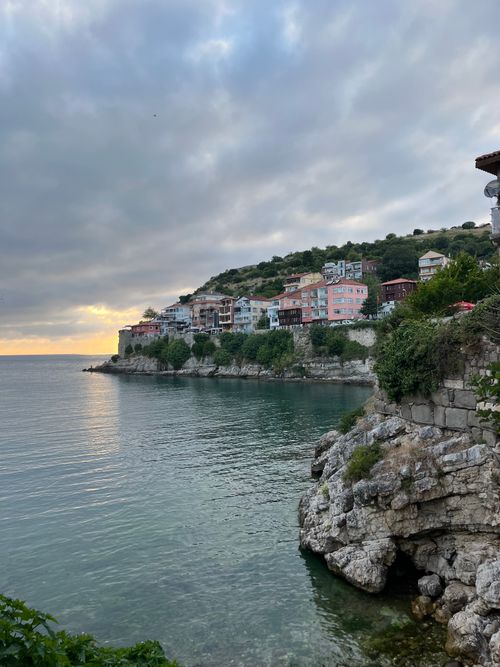 Free Scenic sunset view over Amasra's coastal cliffs with colorful houses and calm sea. Stock Photo