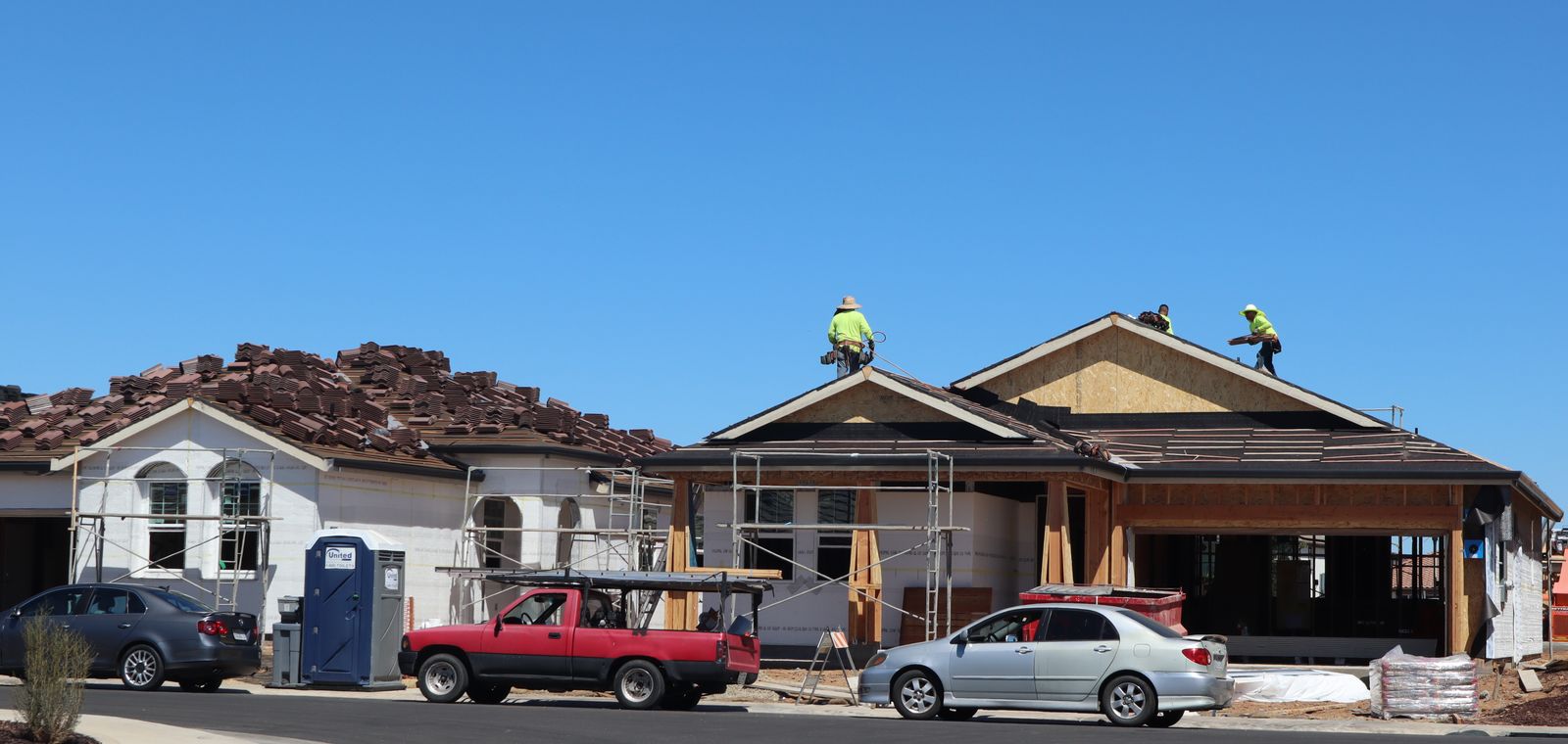 Crew roofing a newly built home