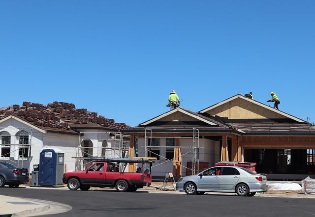 Crew roofing a newly built home