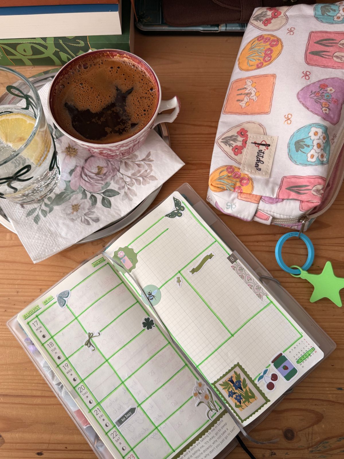 Planner aberto com café e água sobre a mesa, em clima de domingo leve e organizado