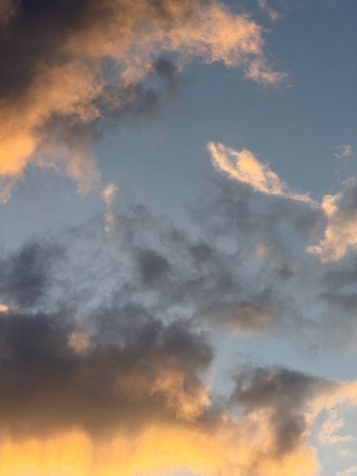 Free Vibrant clouds glow as the sun sets, creating a dramatic sky scene. Stock Photo