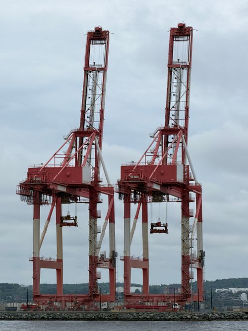 Free Two large red cranes at the busy Halifax Shipping Port on a cloudy day. Stock Photo