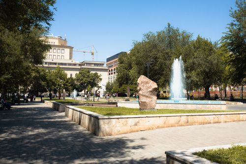 Free A bustling urban park with a central fountain and people enjoying a sunny day. Stock Photo
