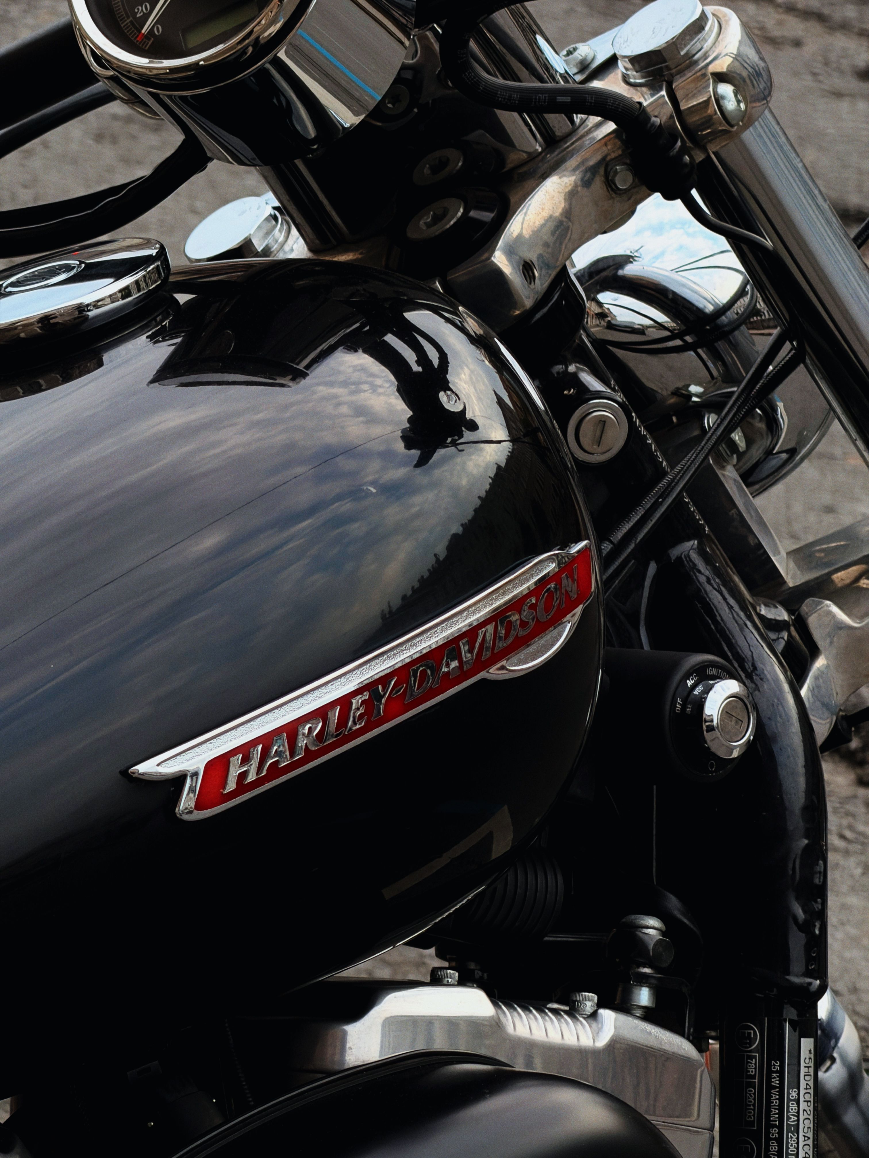 Detailed shot of a Harley-Davidson motorcycle tank reflecting the sky.