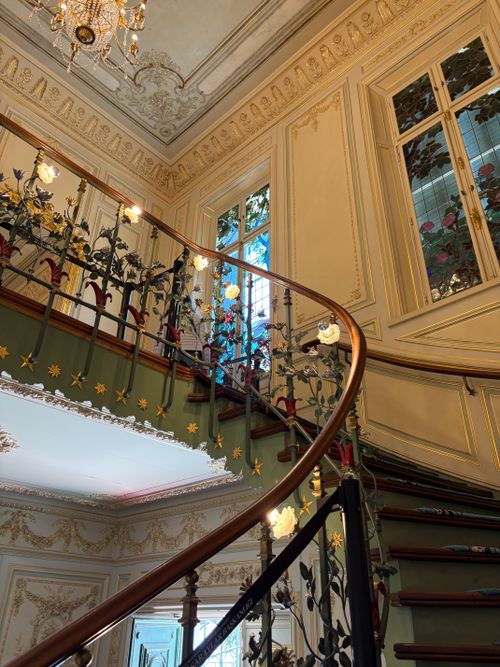 Free Beautiful ornate spiral staircase with intricate ironwork in an elegant historical setting. Stock Photo