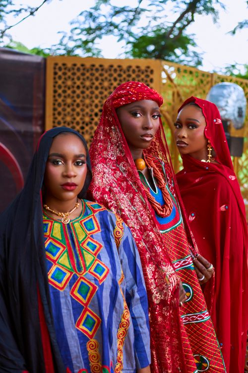 Free Three women in vibrant traditional attire pose outdoors in Kano, Nigeria. Cultural elegance. Stock Photo