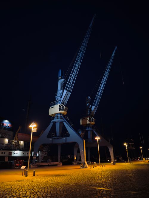 Free Dramatic night view of illuminated cranes at Rostock harbor. Perfect industrial scene. Stock Photo