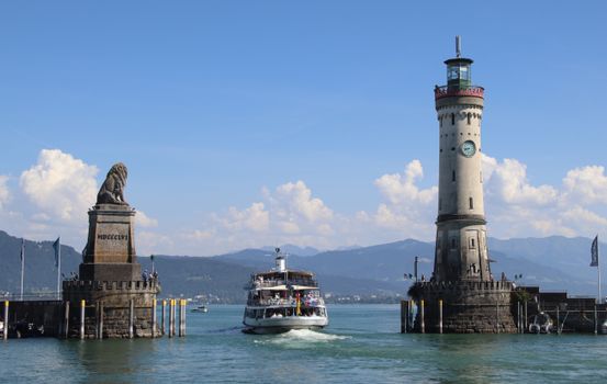 Stylish view of Lindau harbor with iconic lighthouse and lion statue, Bavaria, Germany.