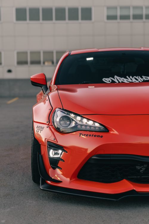 Free Detailed view of a customized red sports car front in an urban setting. Stock Photo