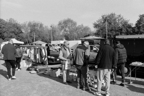 Free A bustling outdoor flea market with people shopping and various stalls on a sunny day. Stock Photo