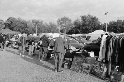 Free A bustling flea market scene captured in black and white, showcasing vintage items and shoppers. Stock Photo