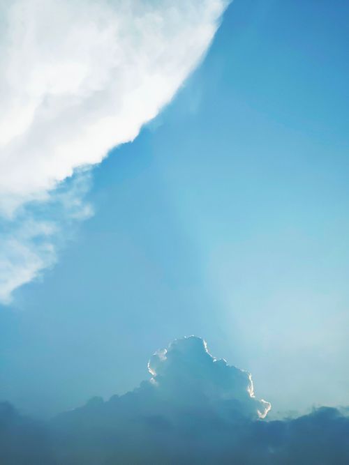 Free Bright blue sky with sunlit cumulus clouds, perfect for backgrounds. Stock Photo