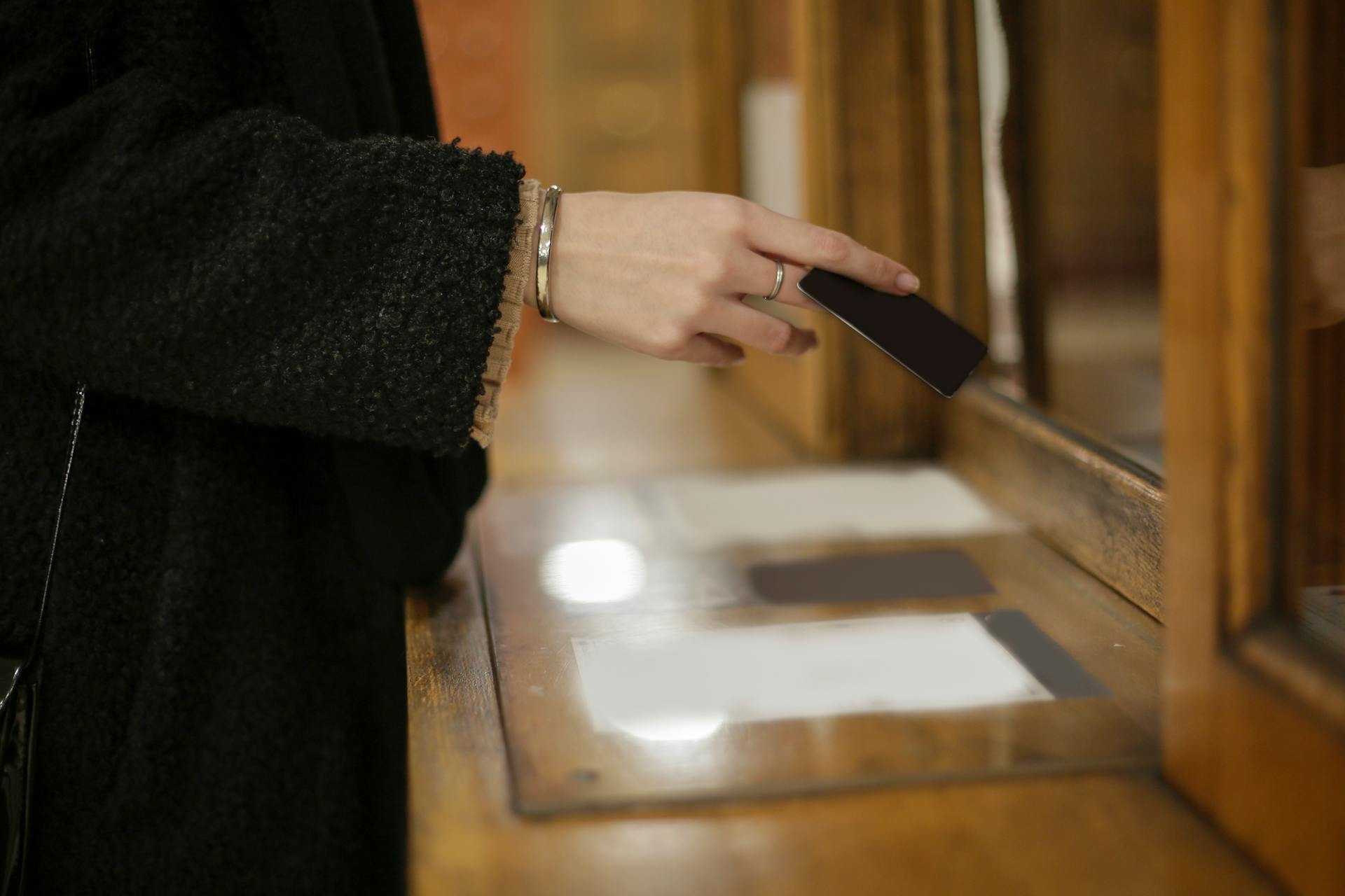 Person in Black Long Sleeve Shirt Holding Black Card