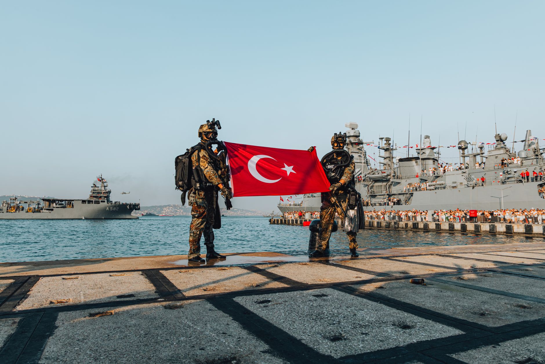 Askeri üs önünde dalgalanan bayraklar ve askerler