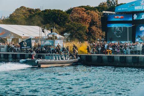 Free Dynamic military demonstration with crowd at a lively waterfront event. Stock Photo