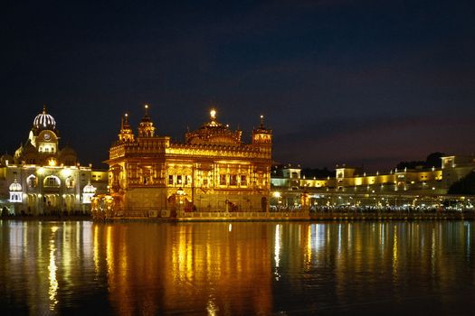 A breathtaking view of the Golden Temple beautifully illuminated at night in Amritsar, reflecting on the sacred water.