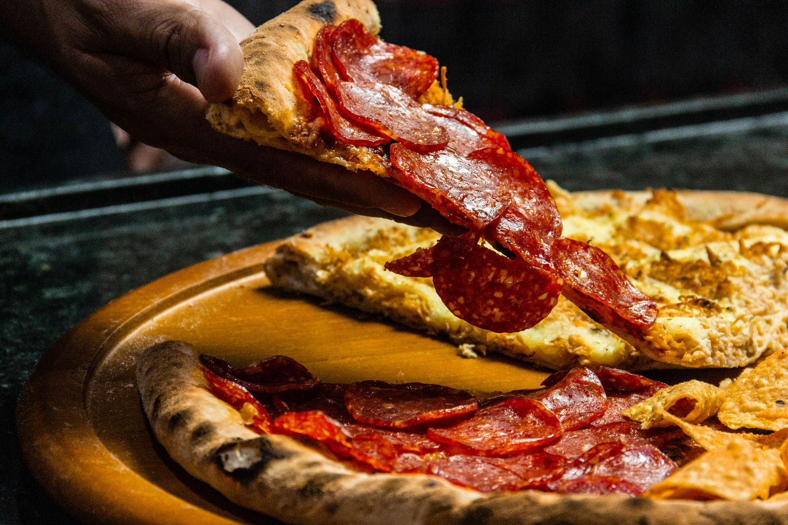 Part de pizza au chorizo soulevée, croûte gonflée et dorée