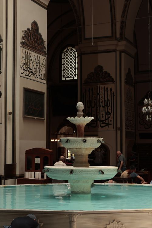 Free Elegant fountain inside a historic mosque with calligraphy-adorned walls. Stock Photo