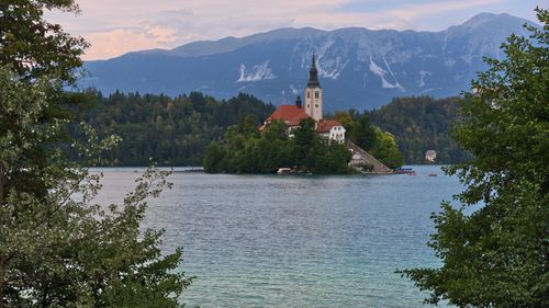 Free Beautiful view of Bled Island with its picturesque church amidst dramatic mountains and clear lake. Stock Photo