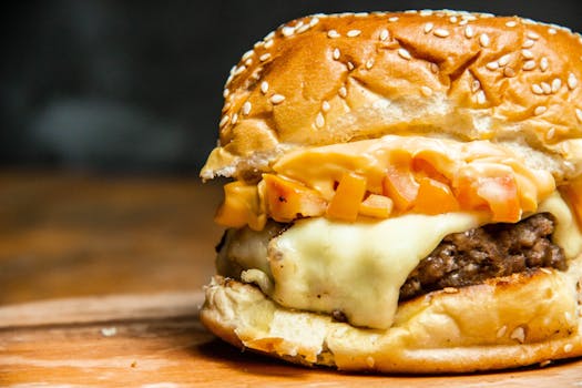 Close-up of a delicious cheeseburger with tomato and sesame seed bun, perfect for fast food enthusiasts.