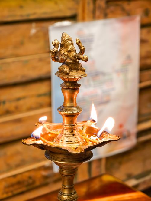 Free A beautifully crafted brass oil lamp with a Ganesha statue, capturing traditional Indian culture and spirituality. Stock Photo