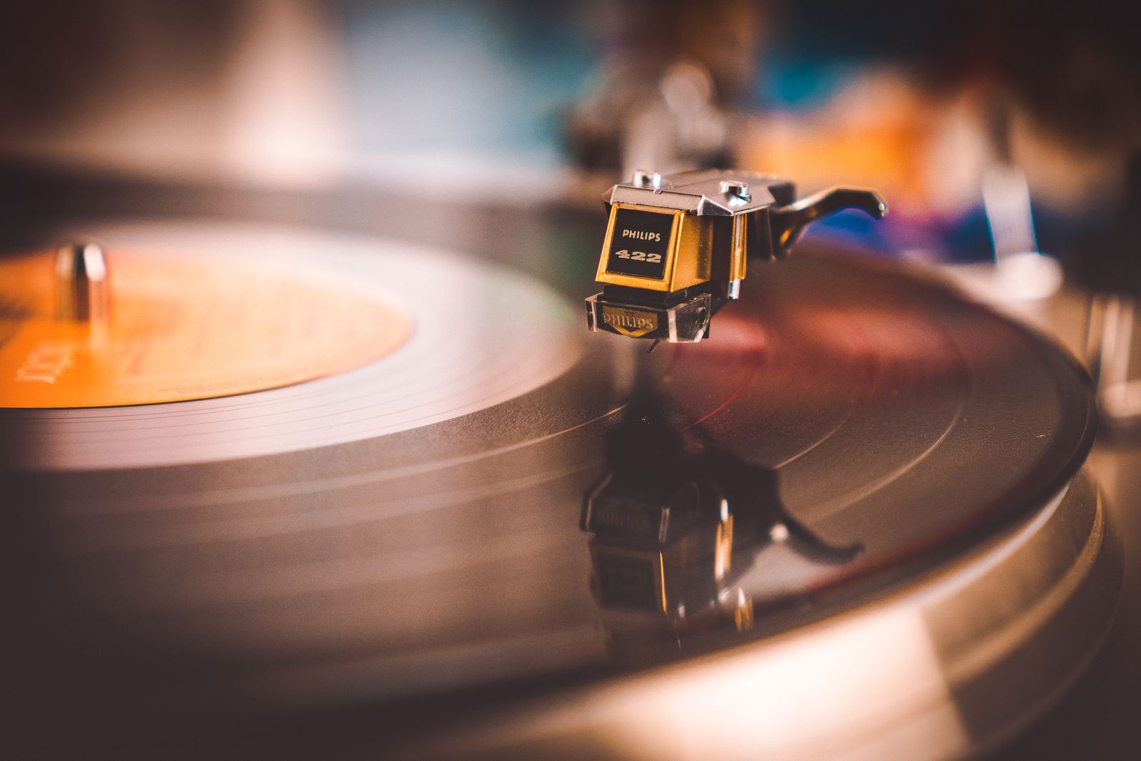 Macro shot of a turntable cartridge and stylus with warm bokeh