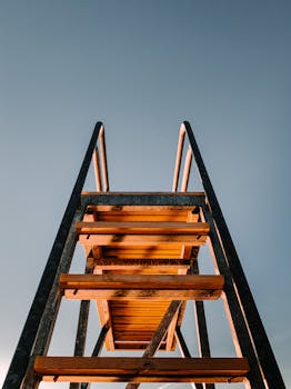 从低角度拍摄的木制楼梯以晴朗的天空为背景，强调了对称性和透视感