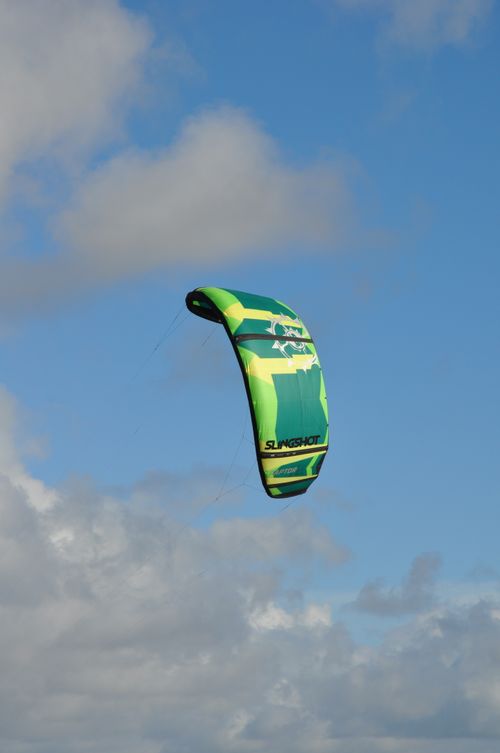 Free A colorful kite surfing glider soaring in a clear blue sky, perfect for water sports enthusiasts. Stock Photo