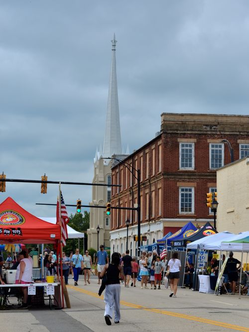 Free Vibrant outdoor festival on Main Street in York, SC featuring vendor tents and a historic church. Stock Photo
