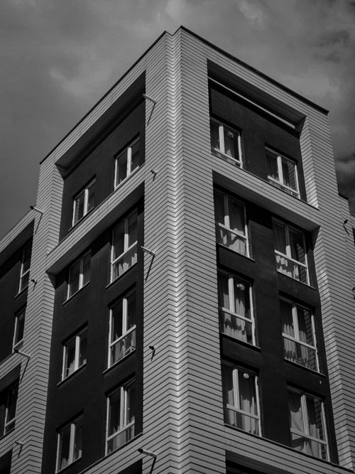 Free Black and white photo of a modern multi-story architectural building captured from a low angle. Stock Photo