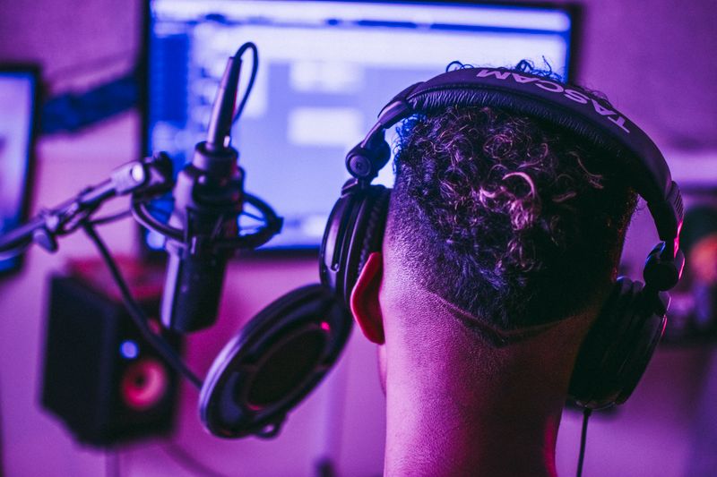 Music producer recording and editing audio with headphones