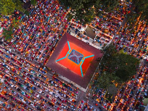 Free Colorful aerial view of a large outdoor gathering at a festival with vibrant decorations and illuminated ambiance. Stock Photo