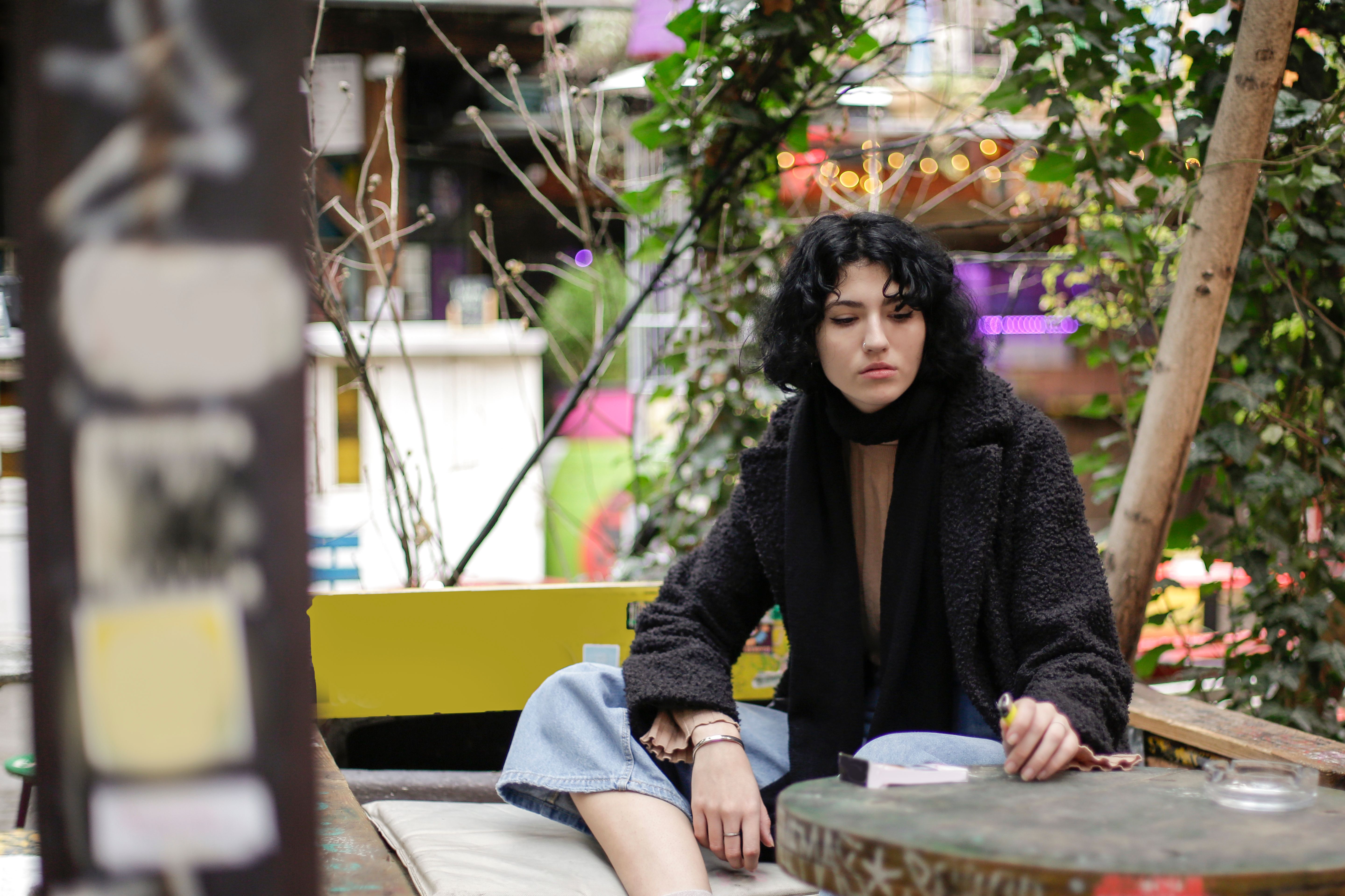 Woman in Black Knit Sweater Sitting on Brown Wooden Bench · Free Stock ...